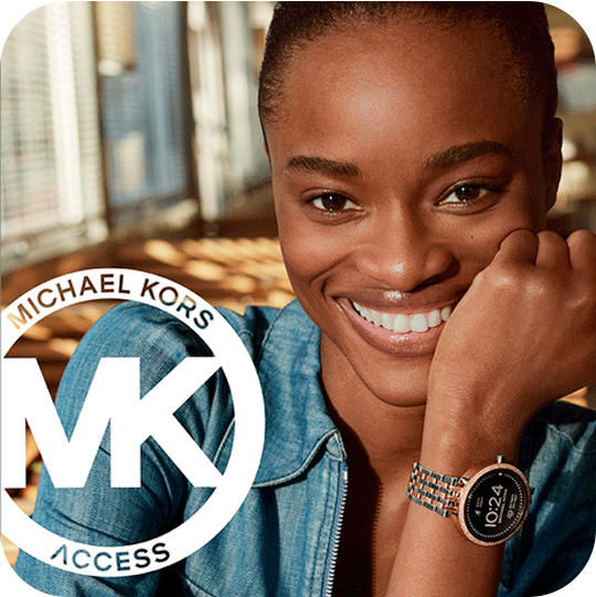 A woman wearing s Michael Kors watcha and smiling