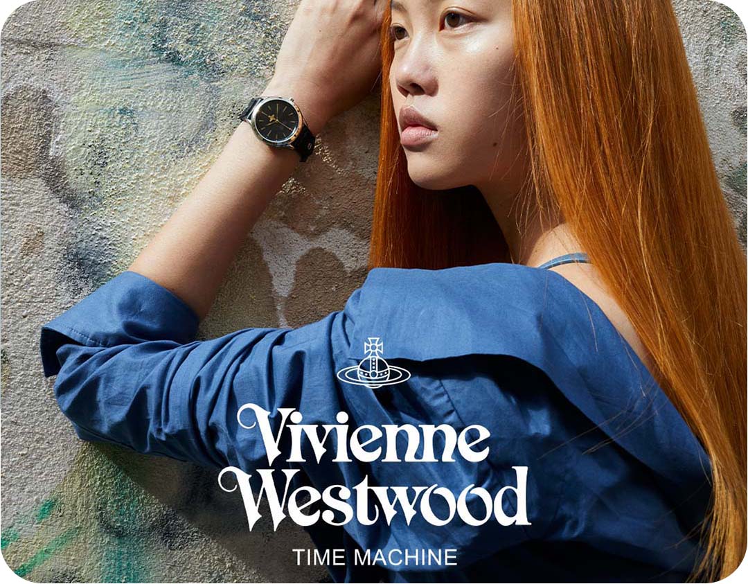 A body shot of a woman with red hair wearing a Vivienne Westwood watch